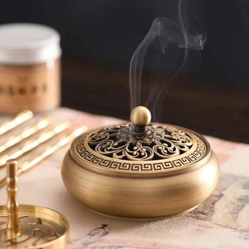 Brûleur d’encens en cuivre avec accessoires raffinés.

